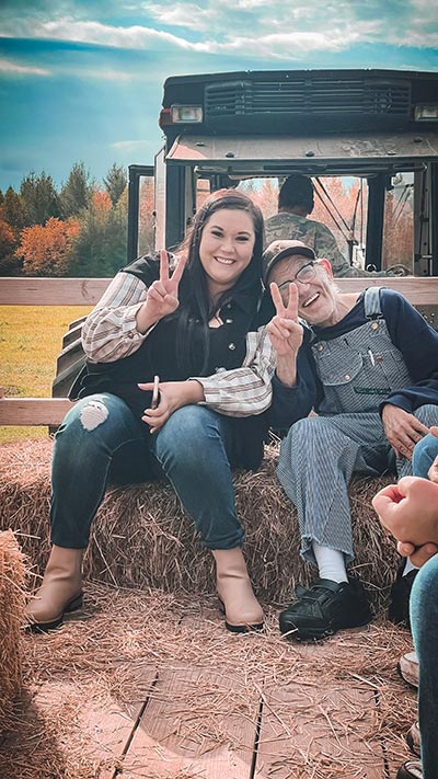 Staff member and client enjoying a hay ride together during day services